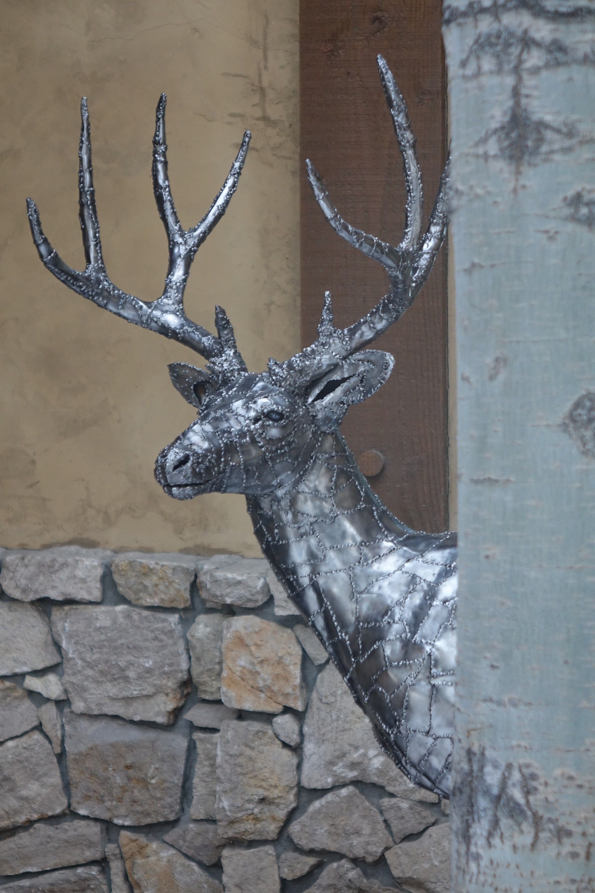 The buck's head and neck in profile, the seams between its steel panels showing along the jaw