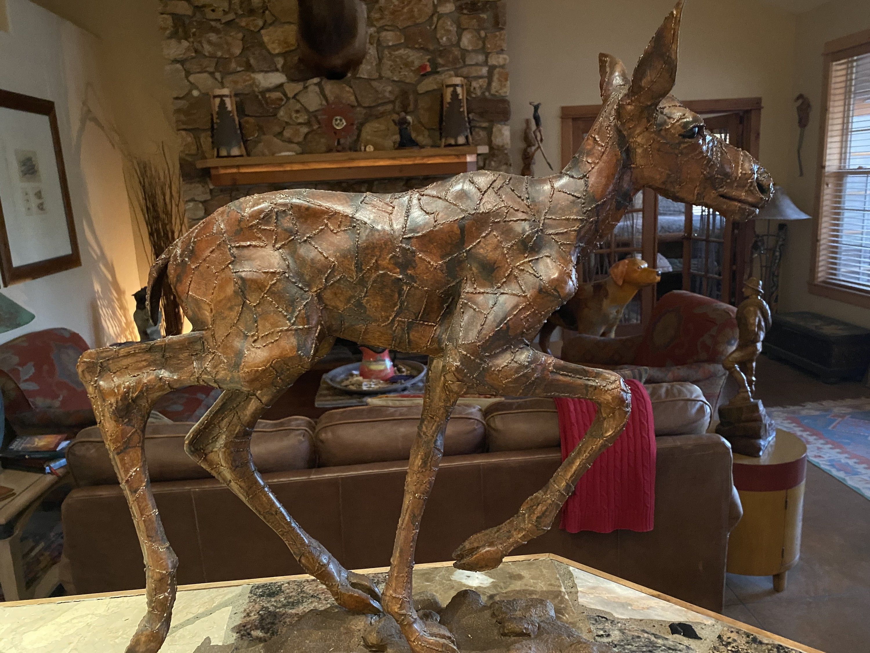 Pointed Down Baby Moose — a bronze baby moose in full side view, one foreleg raised