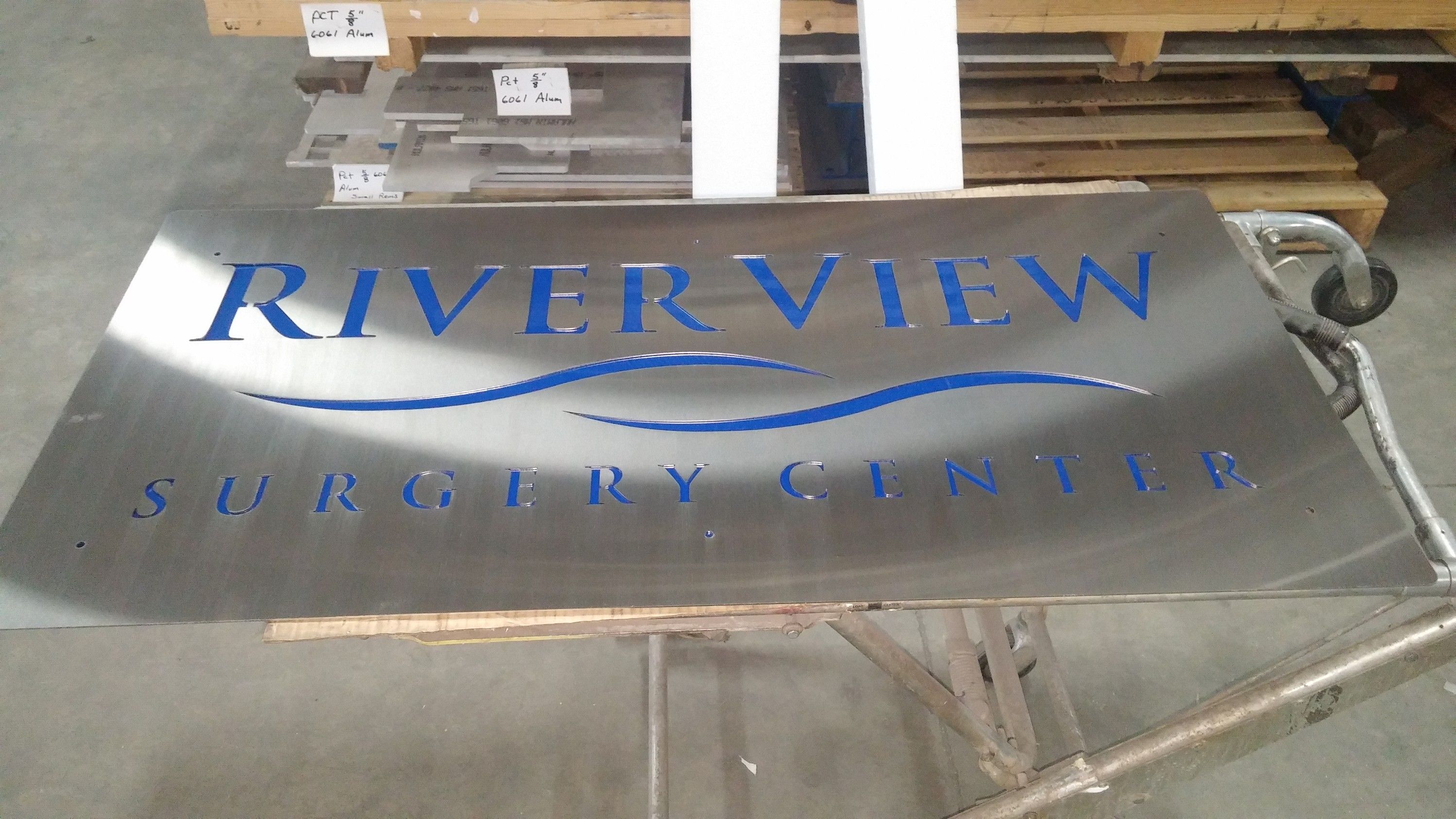 The Riverview Surgery Center sign in the shop, blue acrylic behind brushed stainless