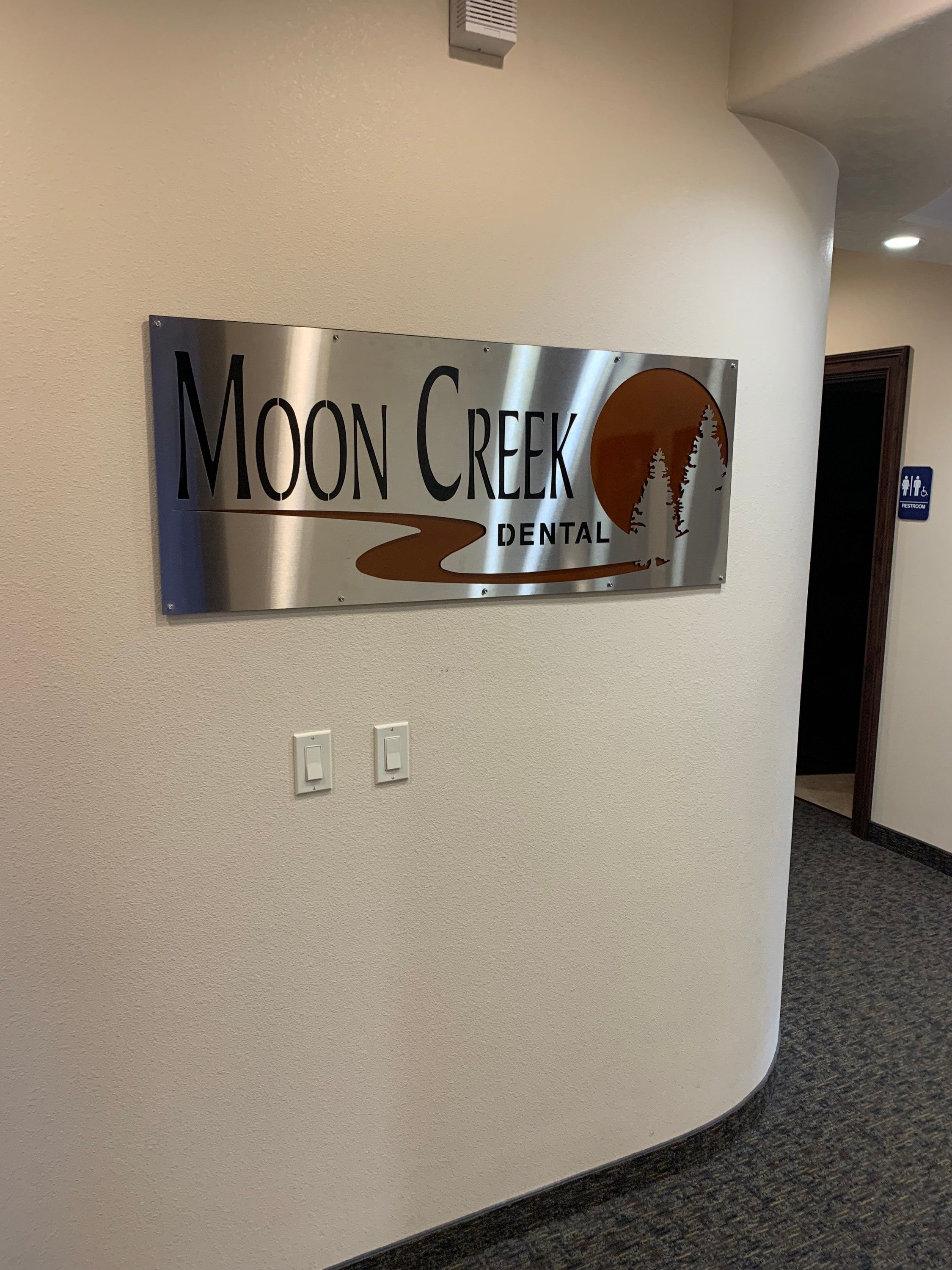 The Moon Creek Dental sign following the curve of the office's rounded interior wall