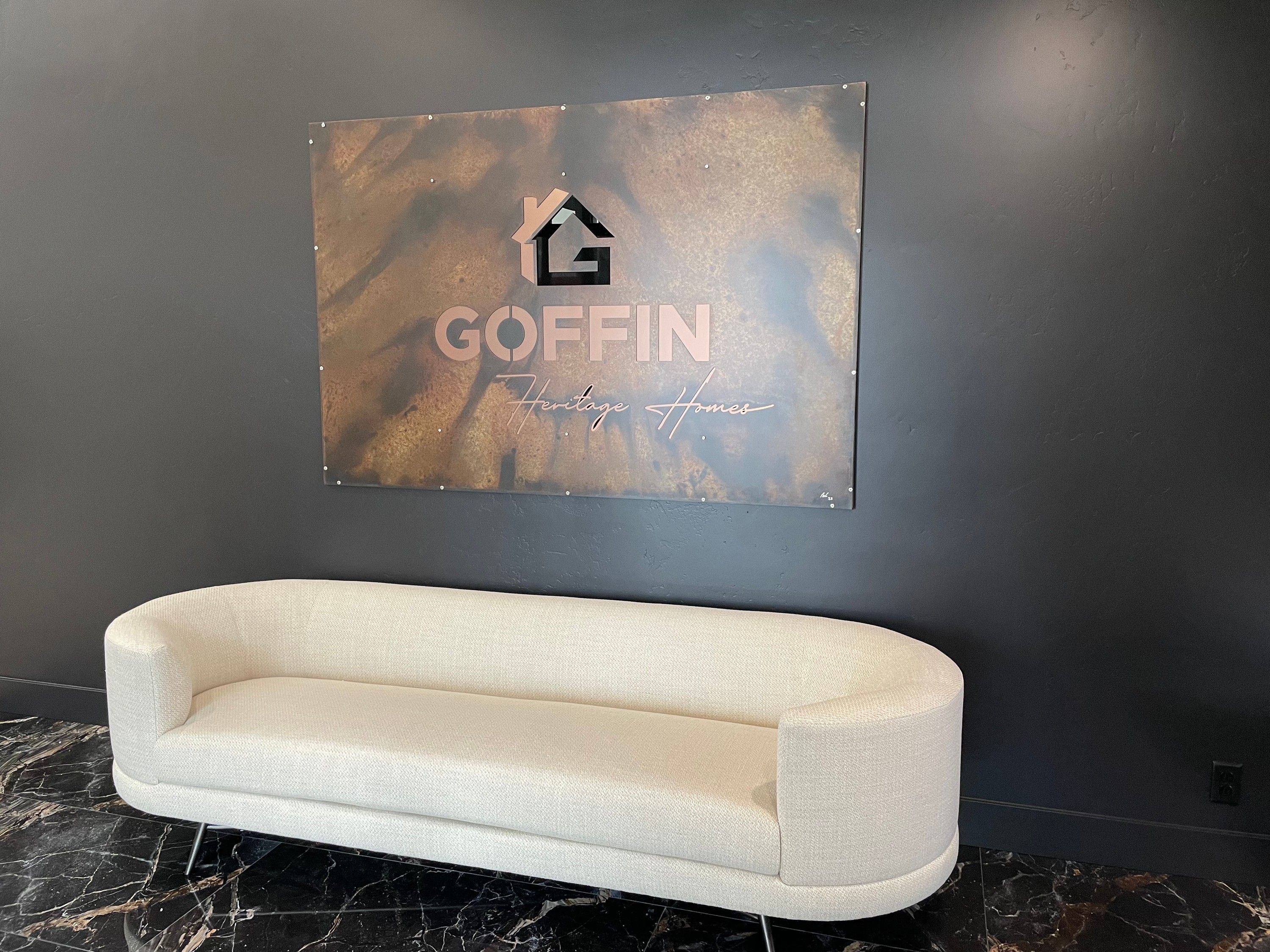 The Goffin Heritage Homes sign installed above a couch in the company office