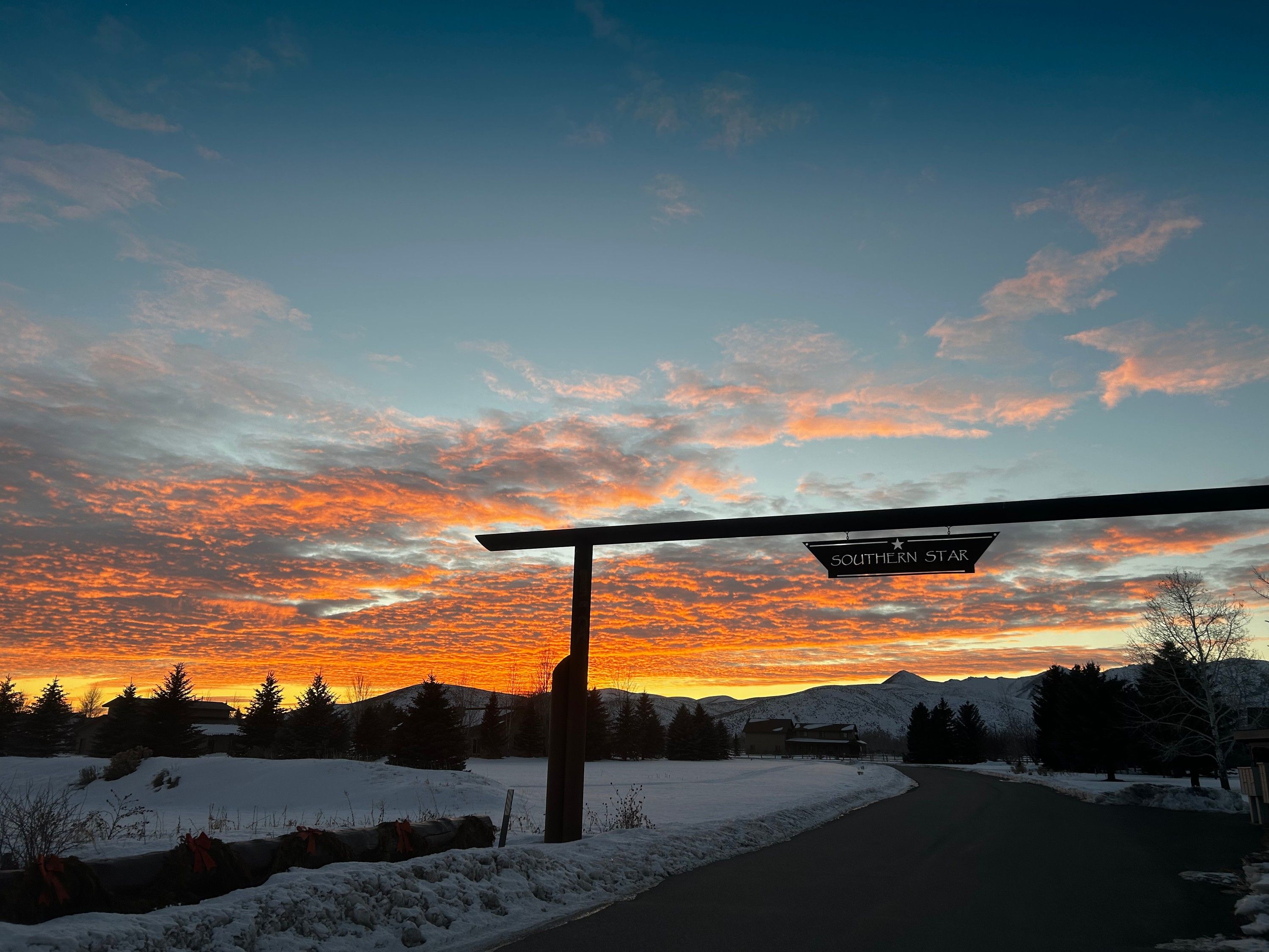 The Southern Star entrance sign hanging from its timber arch at sunset