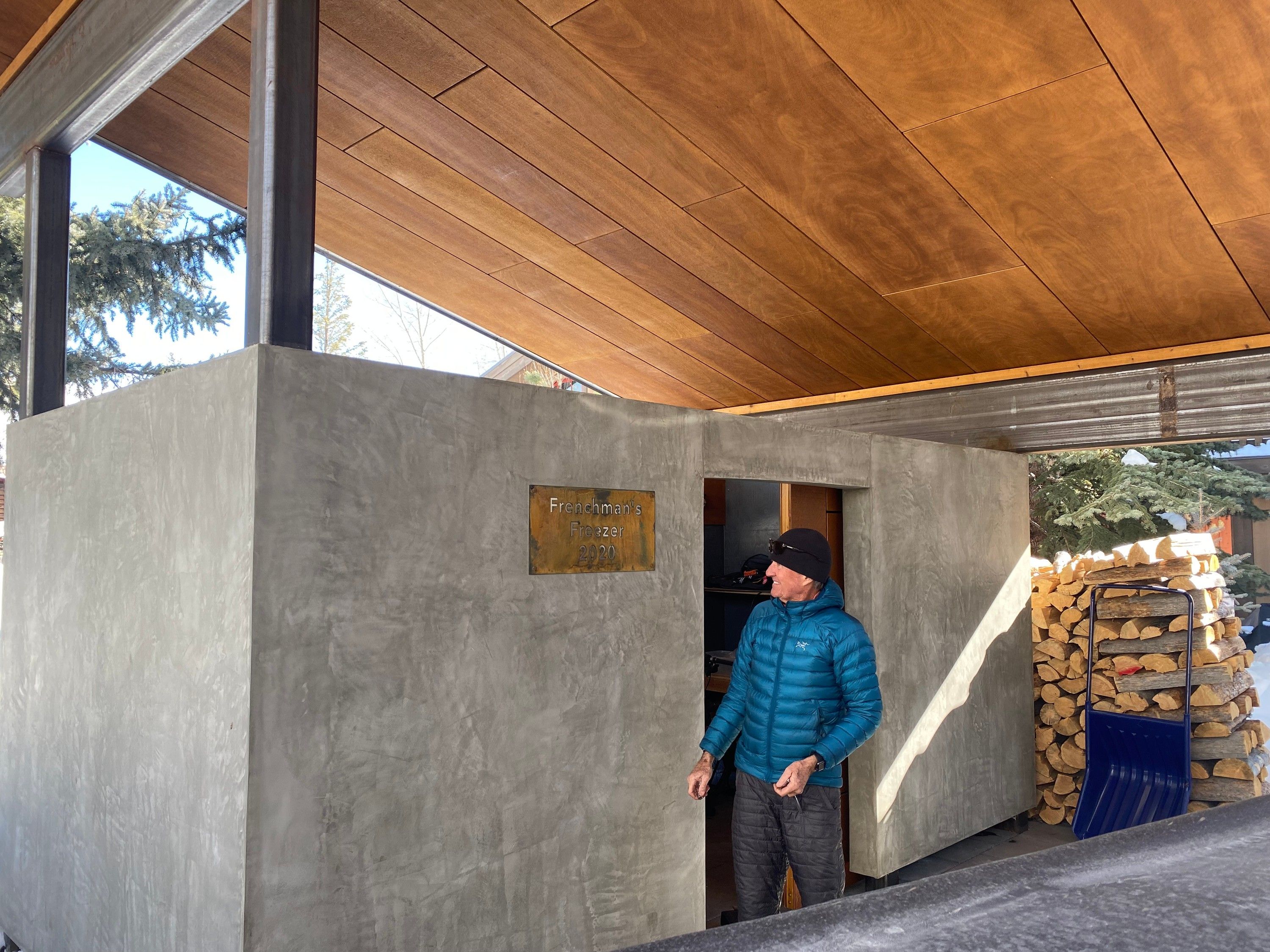 The plaque mounted on the concrete freezer enclosure beneath a wood ceiling, with Russ Lamb standing at its open door