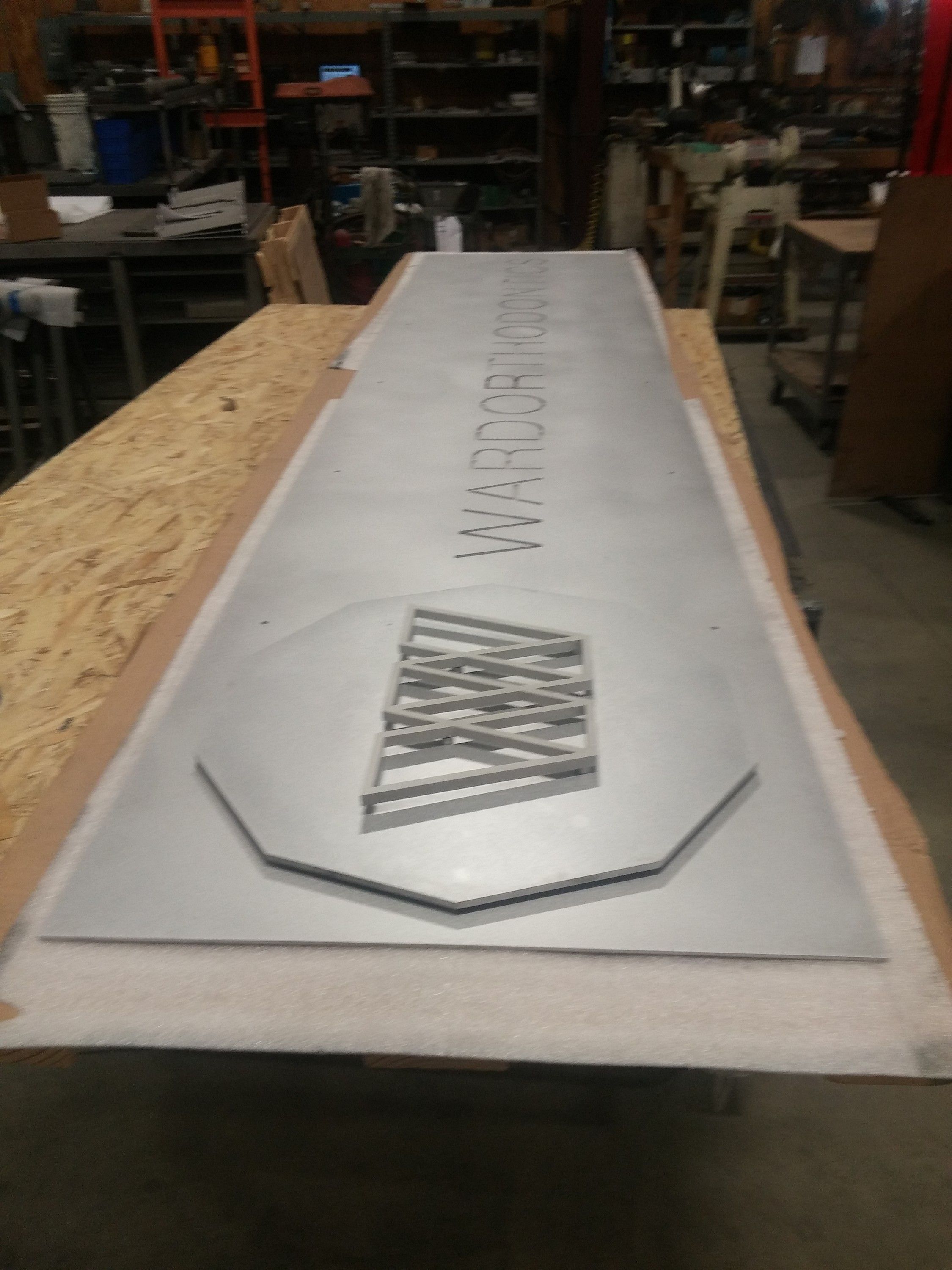 The Ward Orthodontics panel flat on a work table before installation