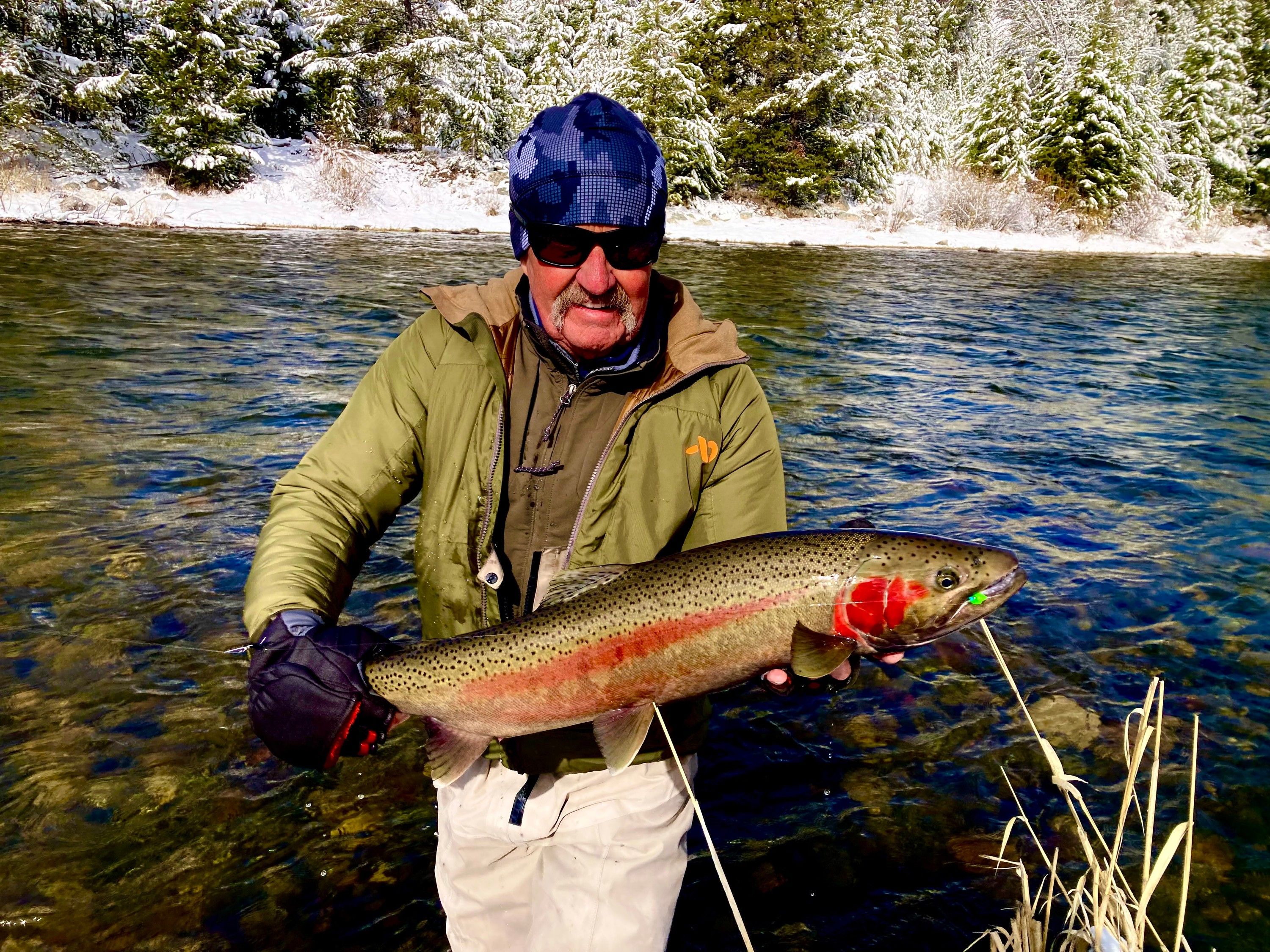 Russ Lamb holding a steelhead on a snowy river